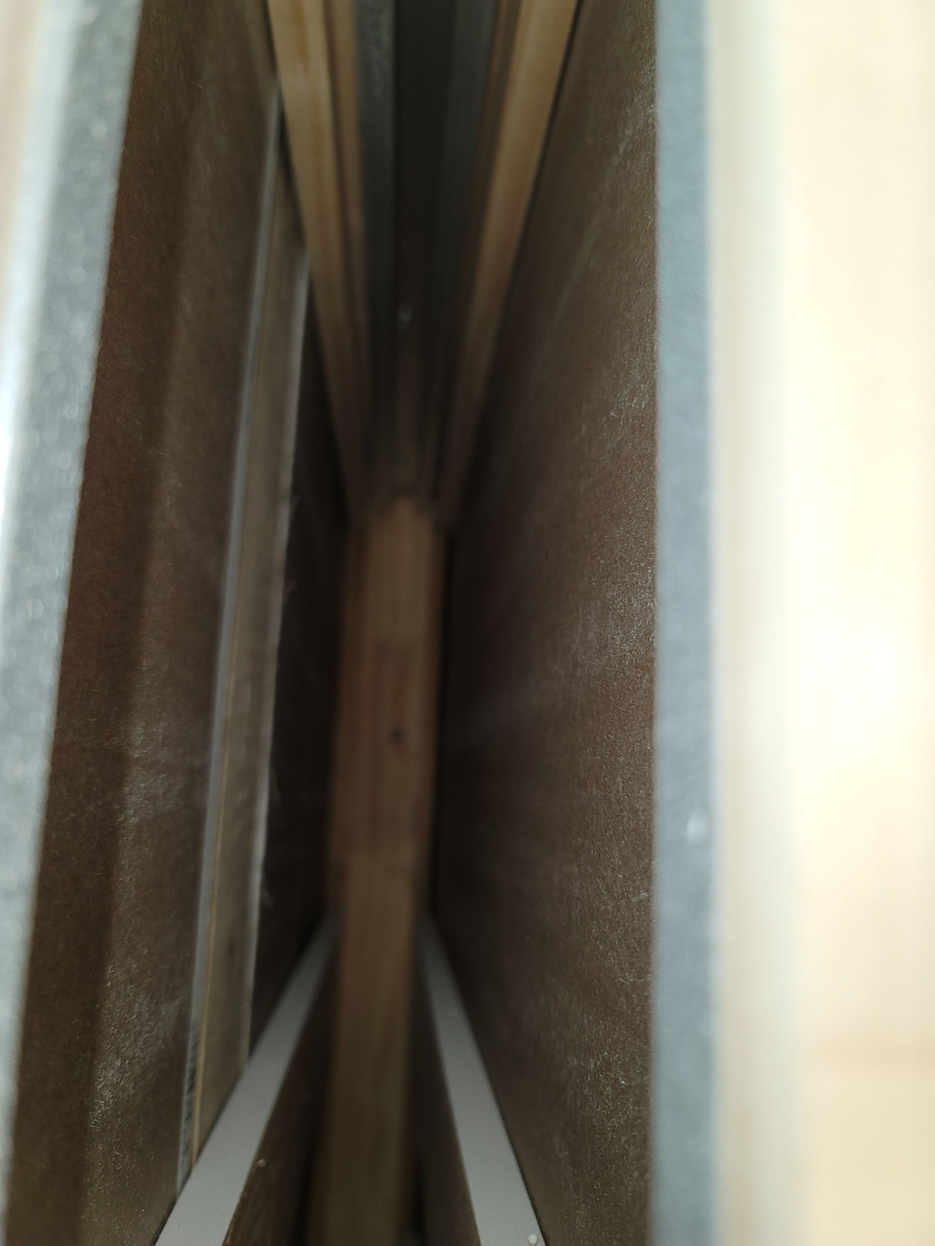 Narrow view between two upholstered panels with a small wooden strip in the center