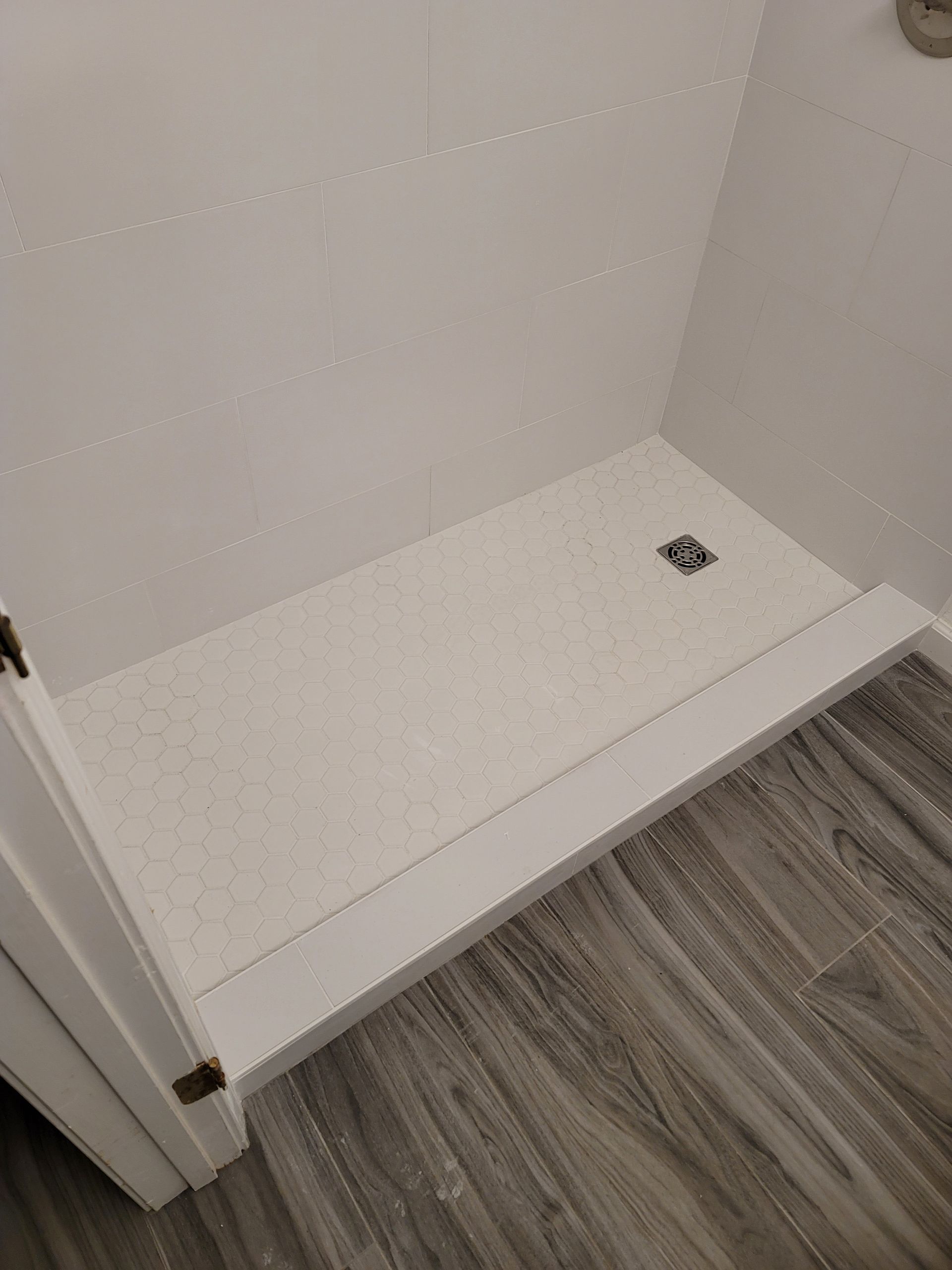 Empty closet nook with white shelf and gray wood floor