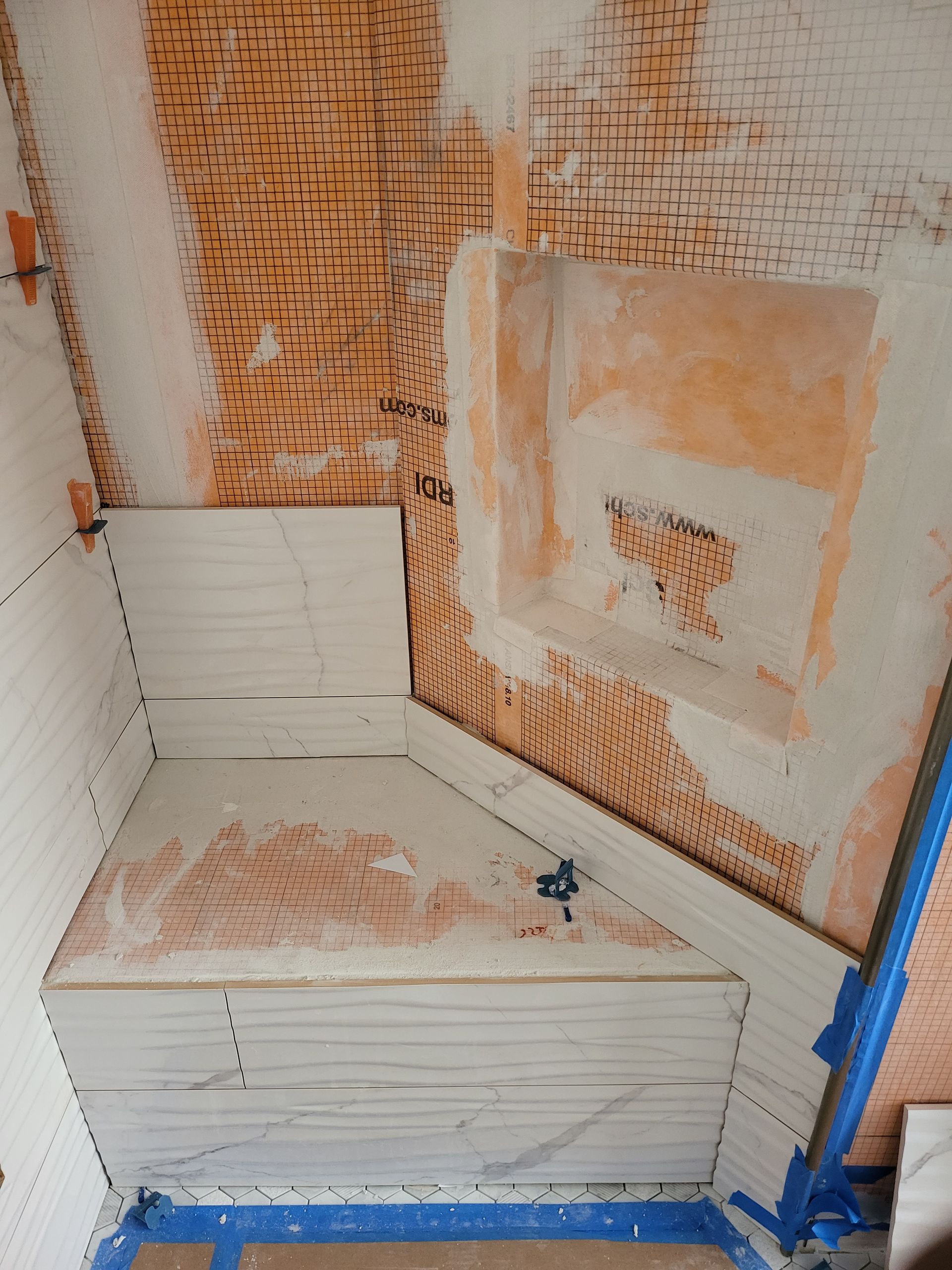 Dusty stairwell with a white built-in step and patched walls, plus a blue pipe on the right.