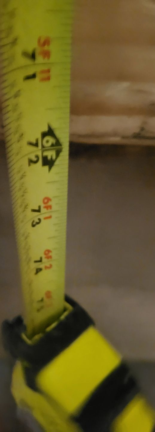 Yellow measuring tape in a person’s hand, with black markings and Korean text.