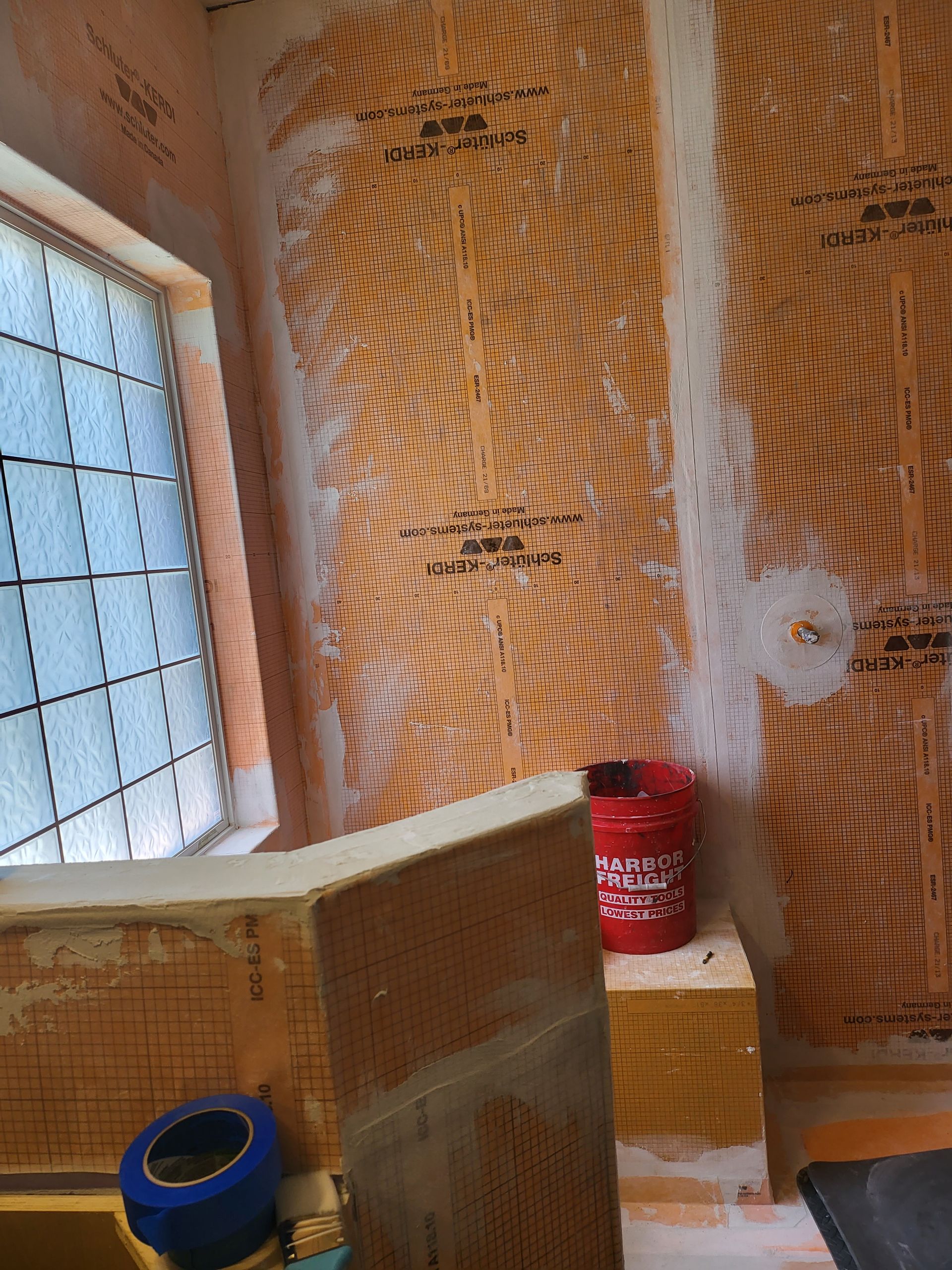 Partially finished room with insulation, a window, and a red can on a work surface