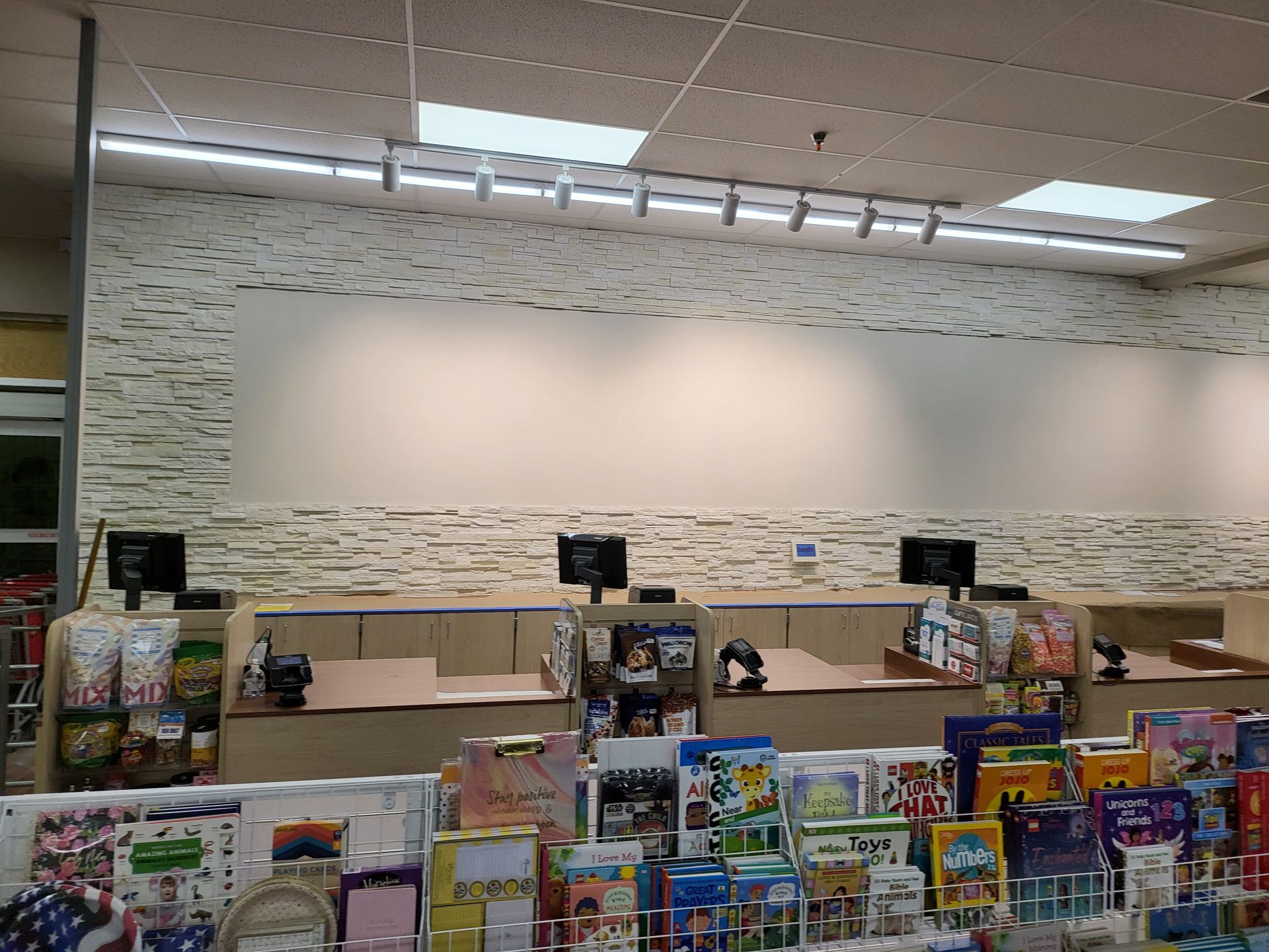Empty retail checkout area with colorful candy and magazine displays in the foreground