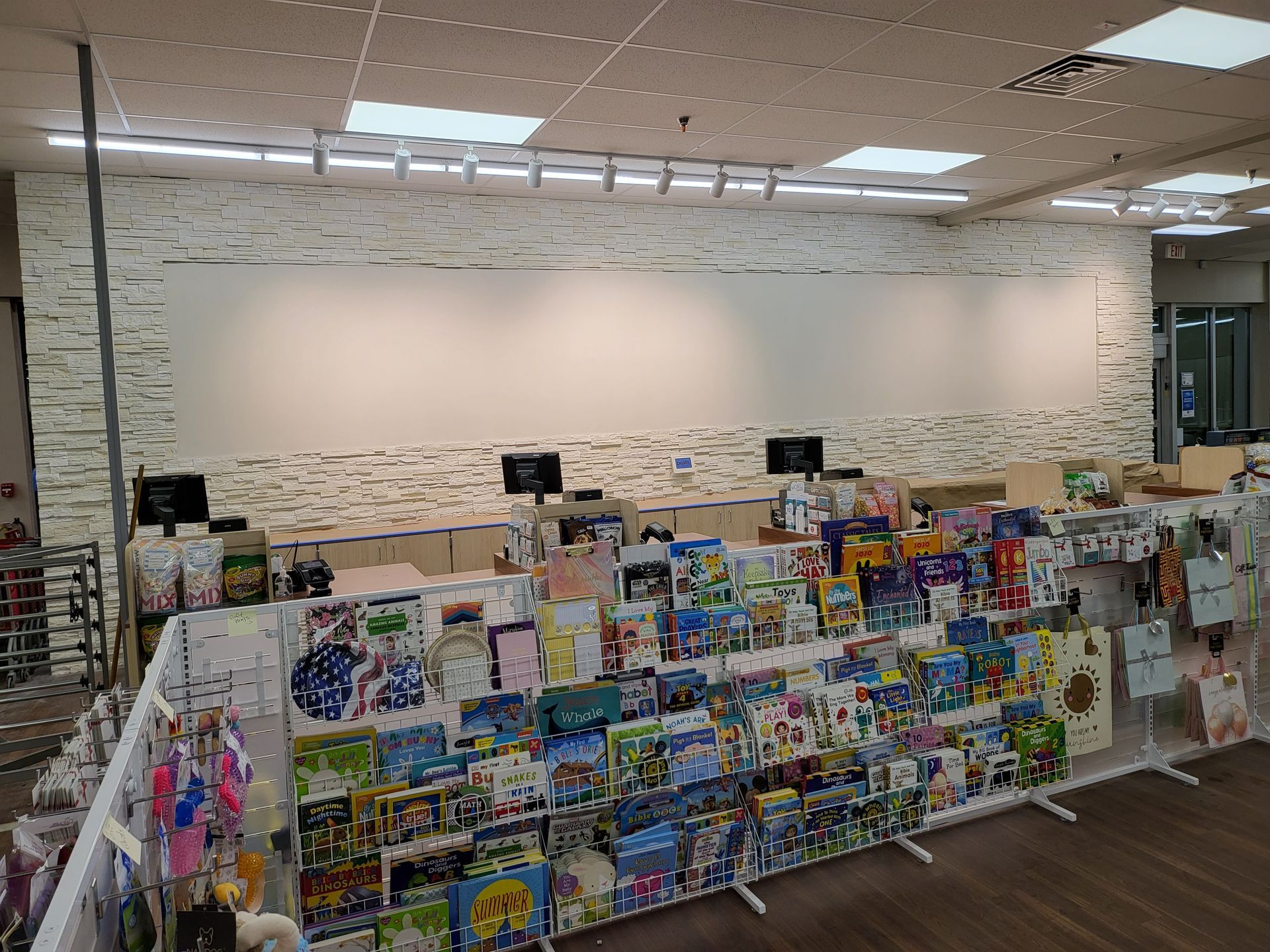 Book and game display in a bright store or library aisle with colorful items on shelves and tables.