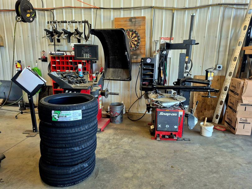Technician mounting tire on rim in workshop