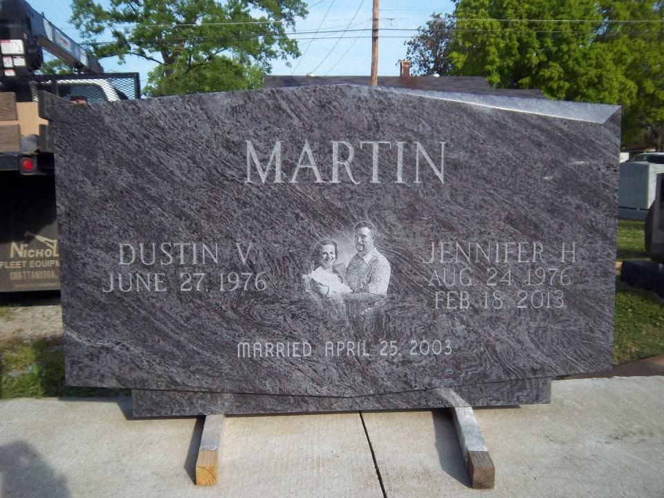 Black headstone with engraved text: 