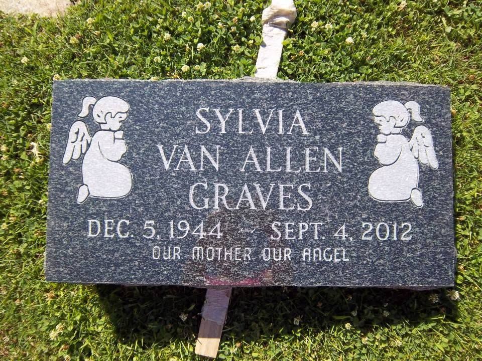 Black headstone with engraved text: 