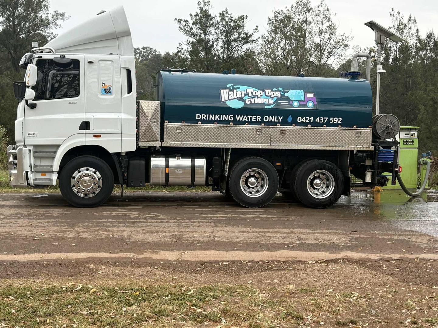 A Septic Truck Under a Gray Metal Roof with A Blue Tank Displaying Business Info — Water Top Ups Gympie in Pie Tamaree, QLD