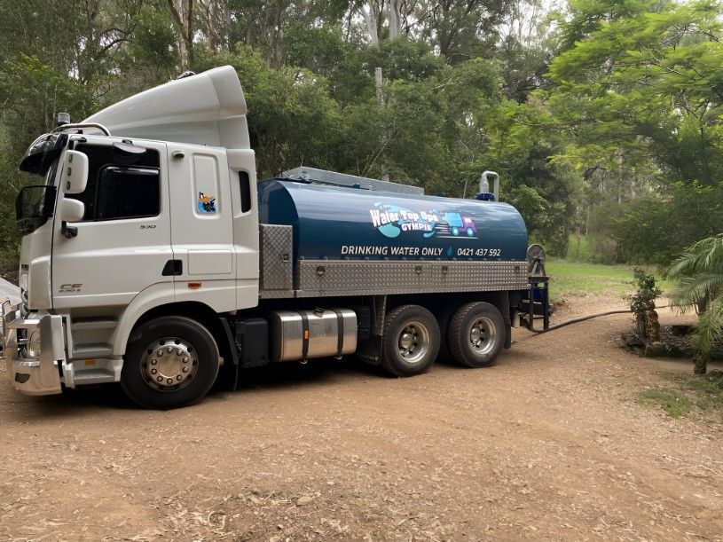 A Large White and Blue Truck is Parked on a Dirt Road — Water TopUps Gympie in Curra, QLD