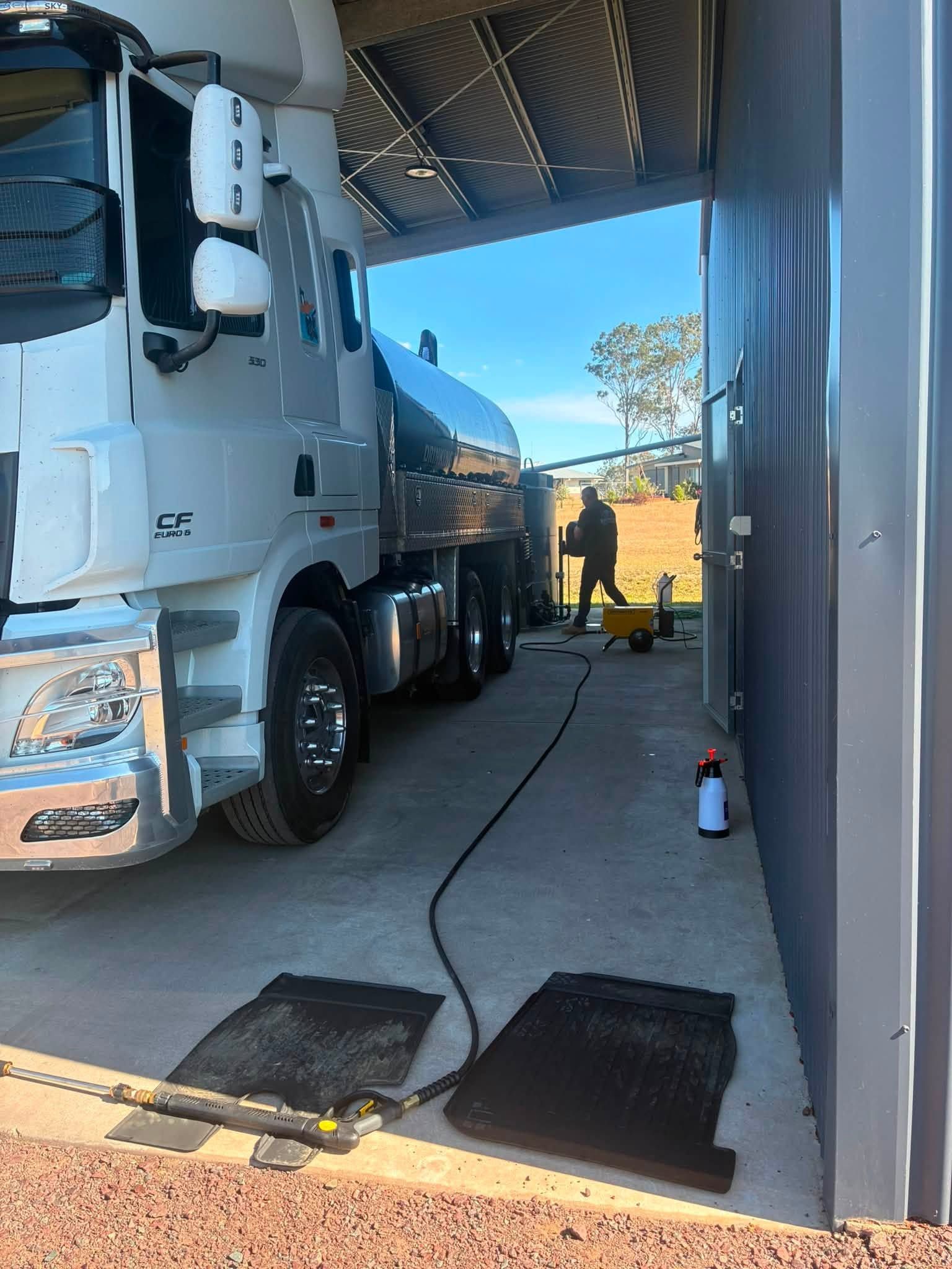 White Semi Truck Inside a Garage Bay with A Person Silhouetted in The Doorway — Water Top Ups Gympie in Jones Hill, QLD