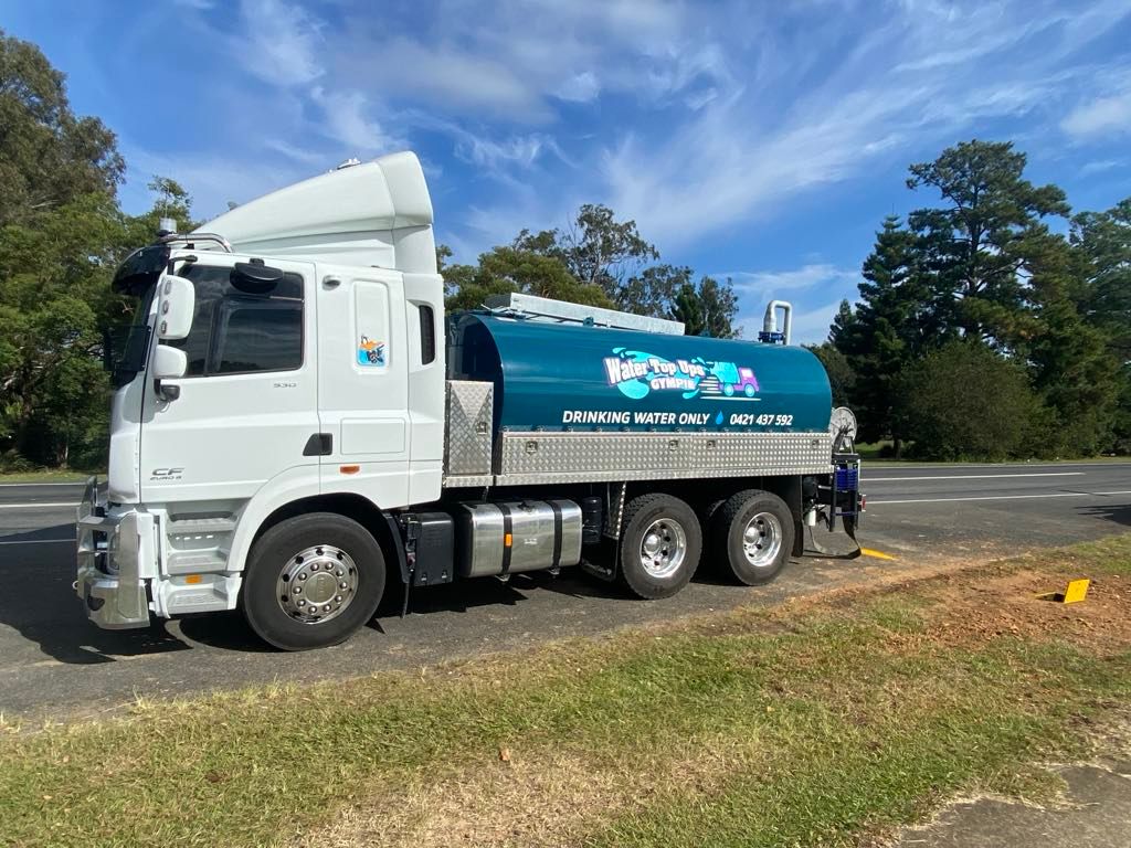 White Tanker Truck Parked on A Grassy Roadside Under a Blue Sky — Water Top Ups Gympie in Curra, QLD