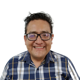 Persona sonriente con gafas y camisa de cuadros azules sobre un fondo blanco.