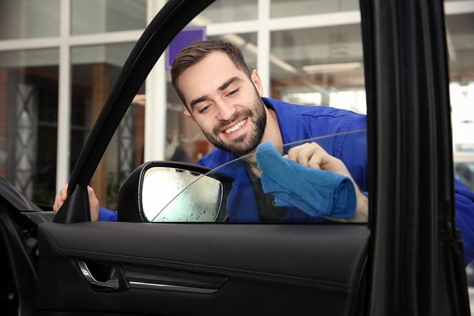man cleaning the car window
