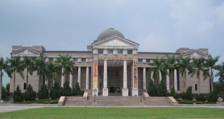 宏偉的新古典主義建築,圓頂屋頂,立柱林立,棕櫚樹掩映在修剪整齊的草坪前。