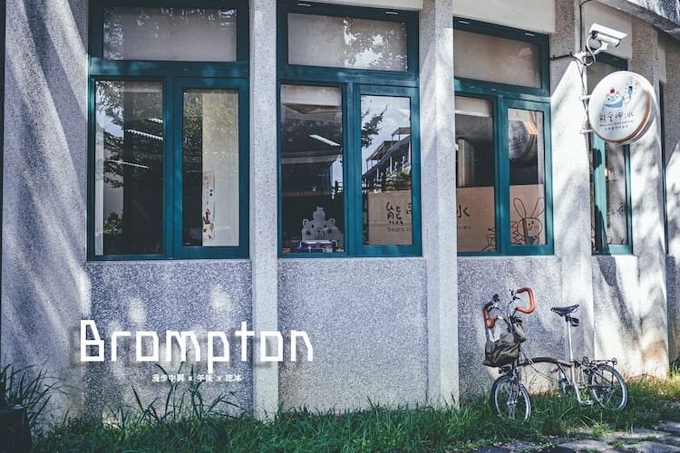 Brompton 商店門面，藍色窗戶，外面停著一輛自行車，牆上掛著一個圓形招牌。