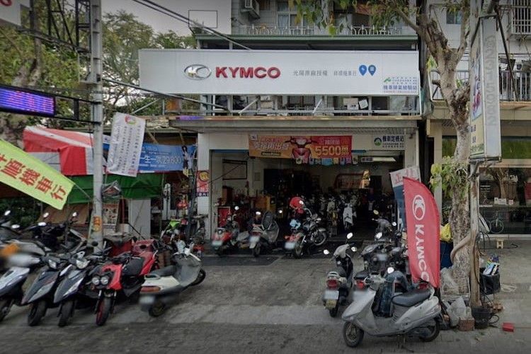 光陽(KYMCO)摩托車經銷店的店面外停放著一排排摩托車。