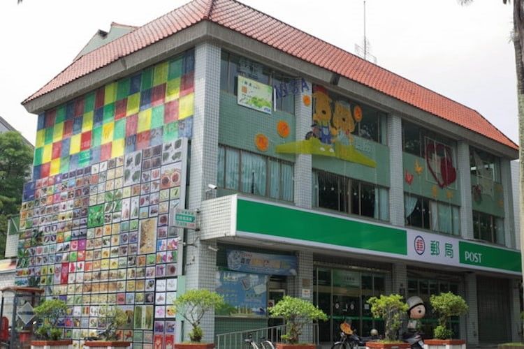 街角的一棟建築,有著色彩繽紛的馬賽克外牆和綠色的店面招牌