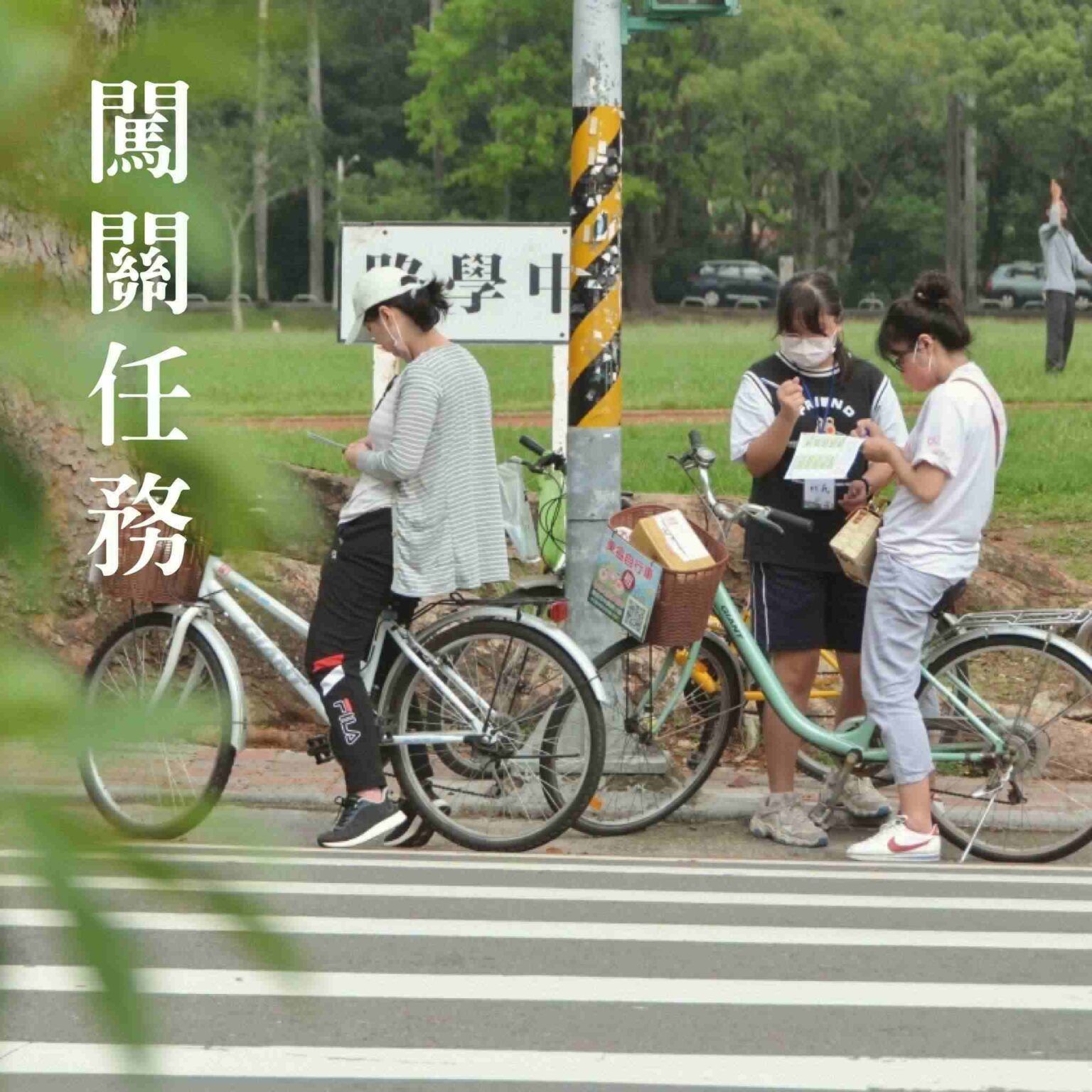 行人騎著腳踏車在公園標誌牌前的斑馬線上看報紙。