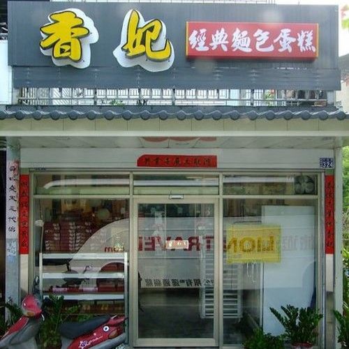 一家中國麵包店的店面，黃色招牌，玻璃入口。