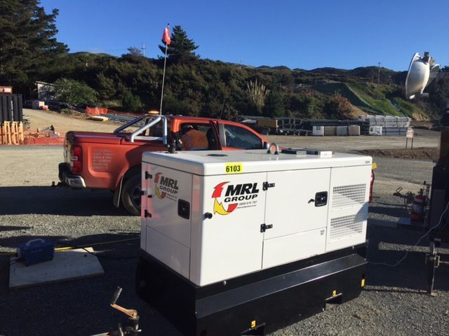 A red truck is parked next to a mrl generator