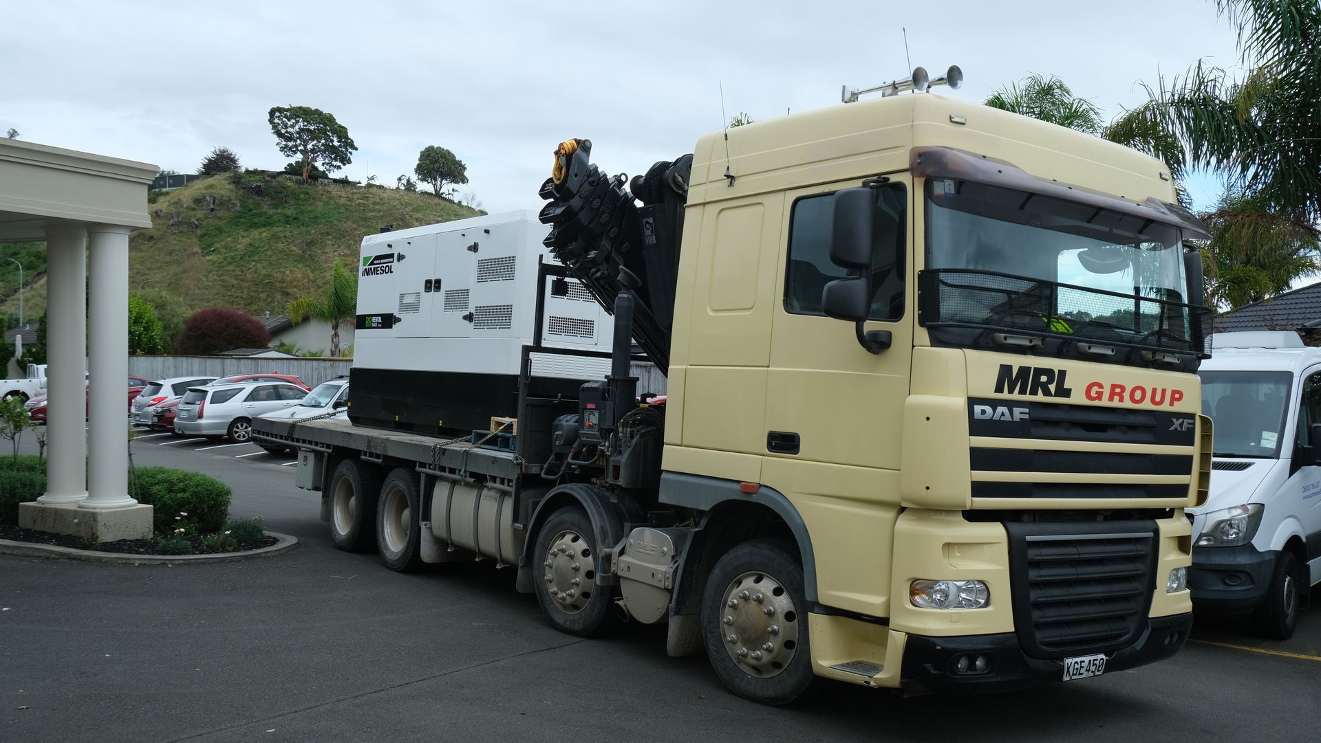 A large truck with a crane on the back is parked in a parking lot.