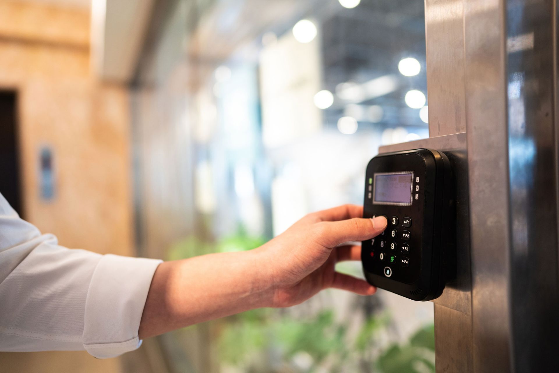 A Person Using A Keypad To Open A Glass Door — Thornton, CO — Thornton Westminster Locksmith