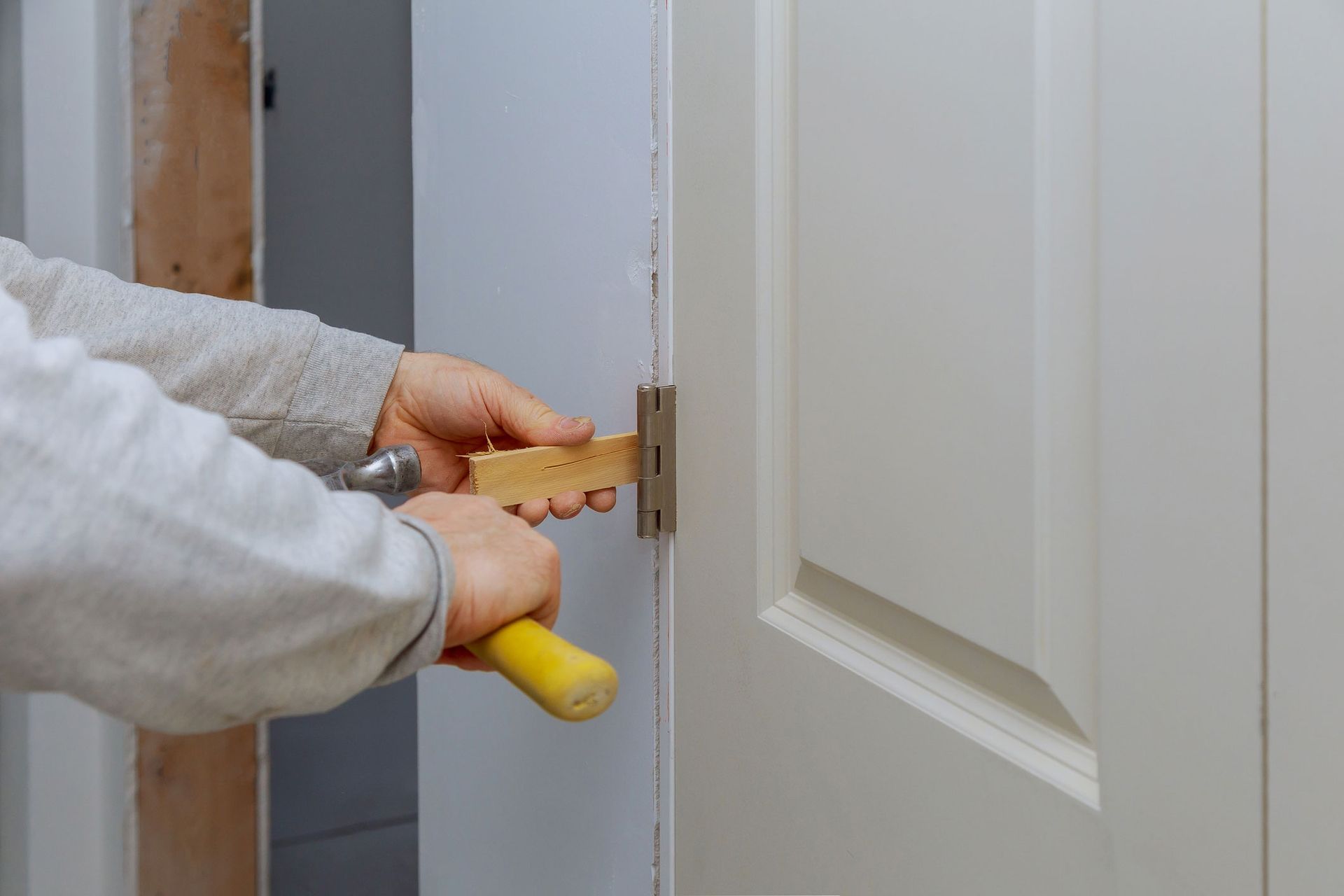 A Person Fixing A Door With A Hammer — Thornton, CO — Thornton Westminster Locksmith