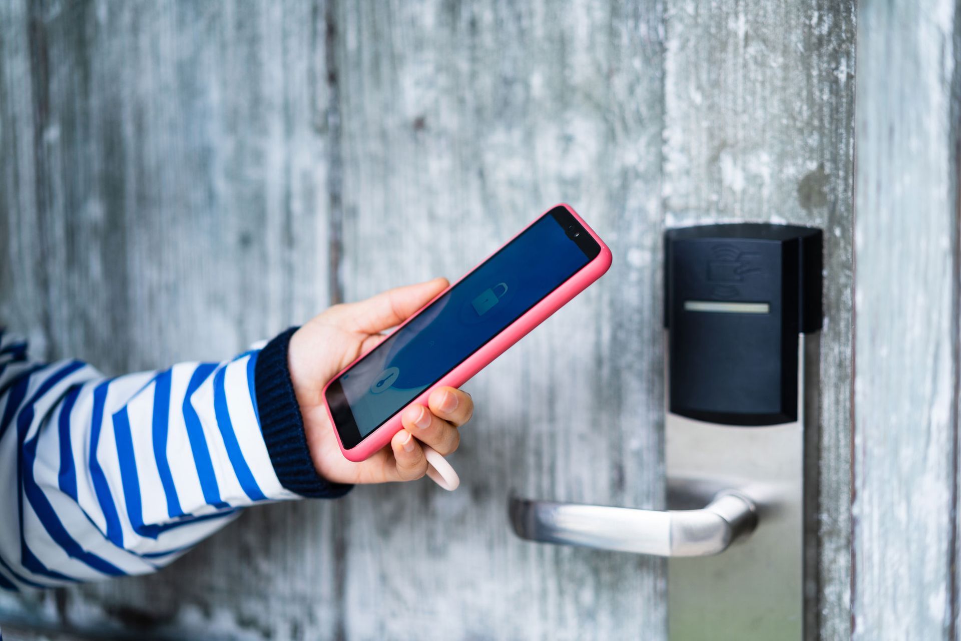 A Person Using A Smart Phone To Open A Door — Thornton, CO — Thornton Westminster Locksmith