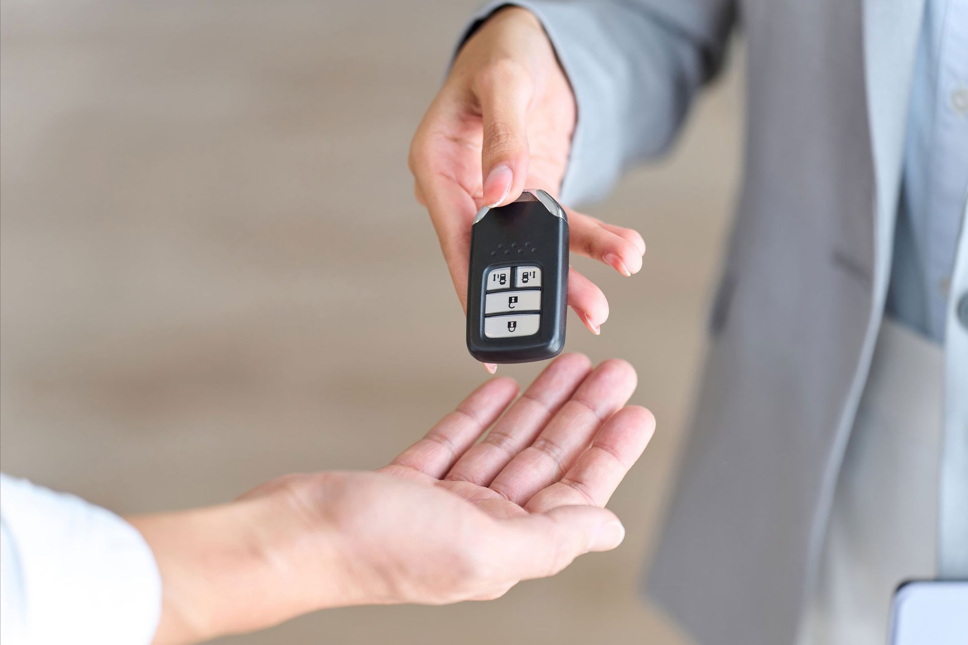 A Woman Handing A Car Key To A Man — Thornton, CO — Thornton Westminster Locksmith