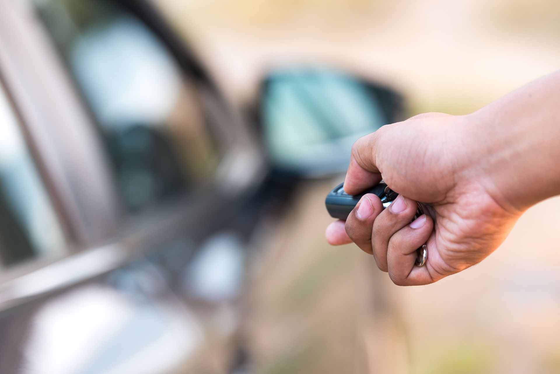 A Person Holding A Remote Control In Front Of A Car — Thornton, CO — Thornton Westminster Locksmith