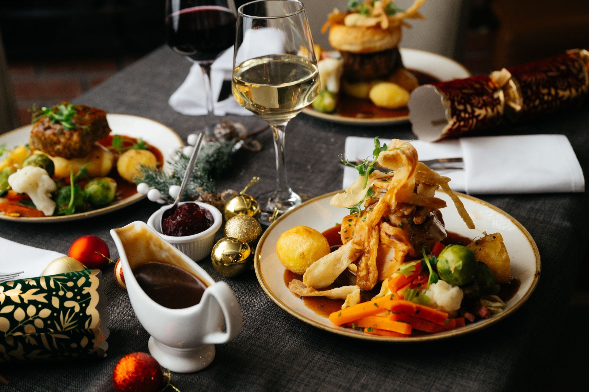 Elegant dinner table with plated gourmet dishes, wine glasses, and candles in a dimly lit setting
