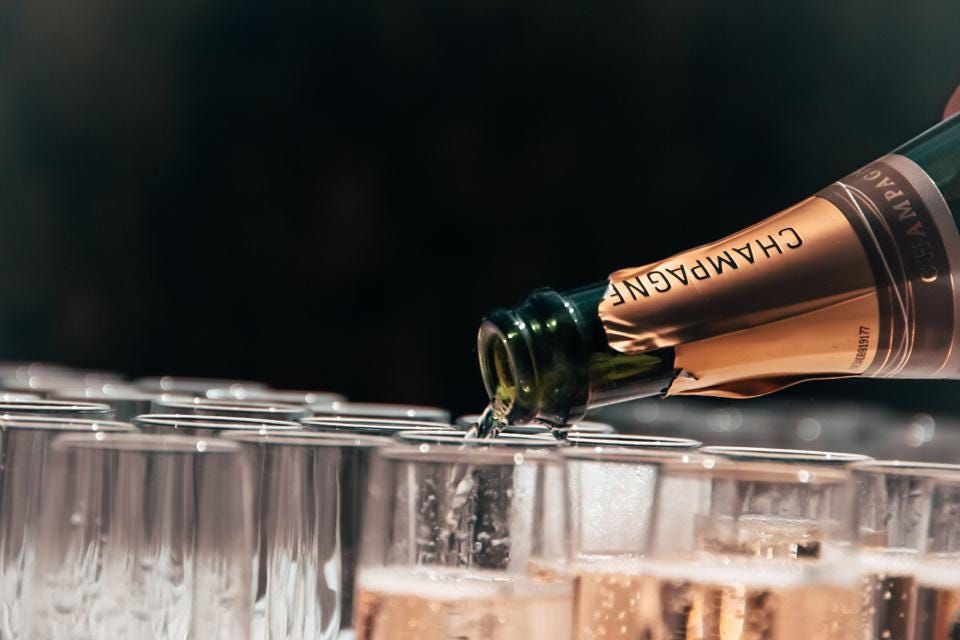 Champagne being poured into a row of glasses at a celebration