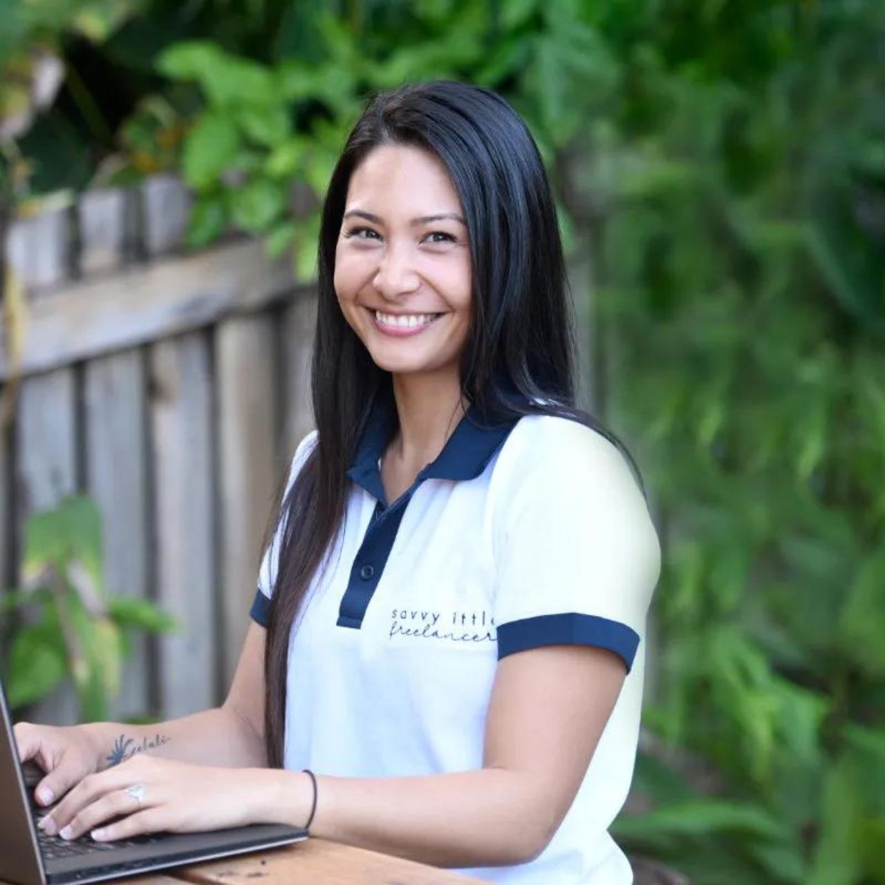 Beck Hall from The Savvy Squad - a woman is smiling while using a laptop computer