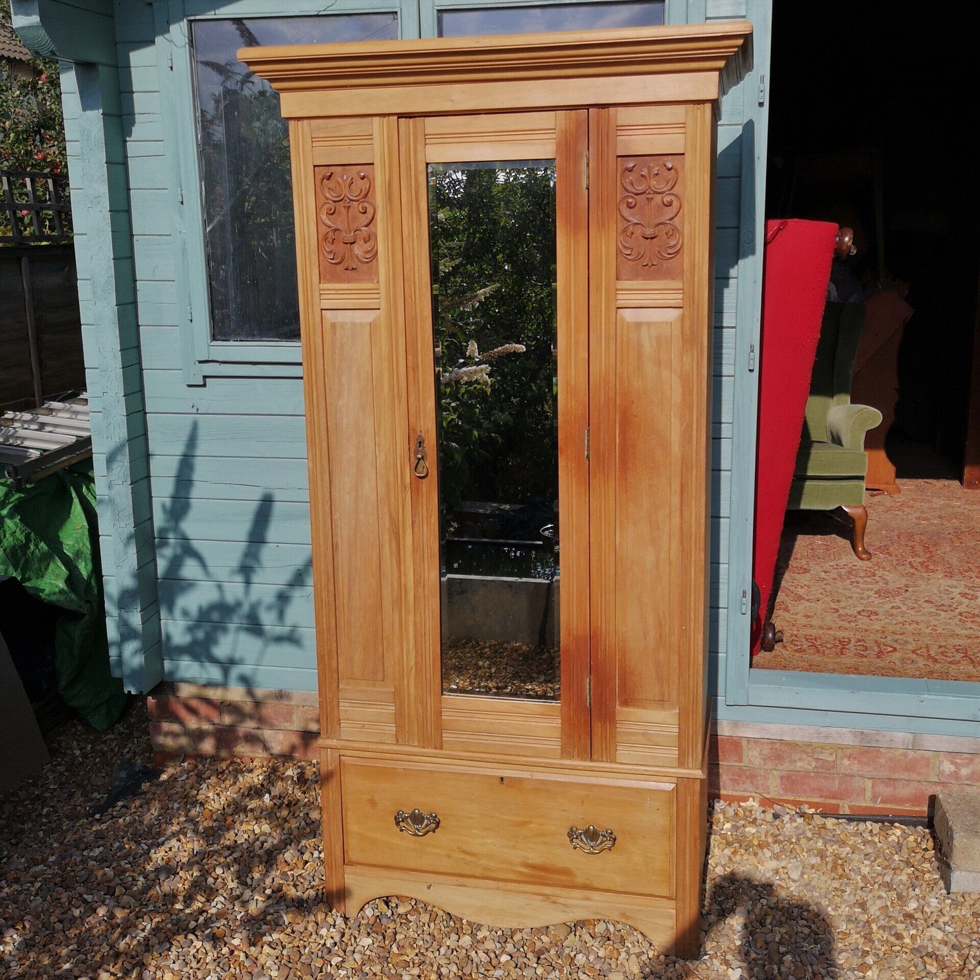 A wooden wardrobe with a mirror on the door