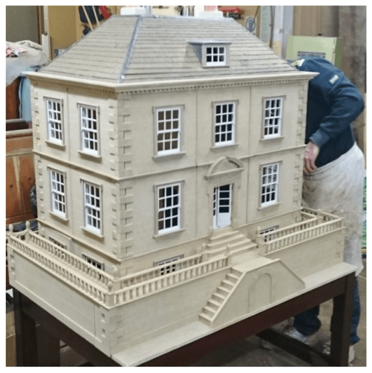 A doll house is sitting on a wooden table