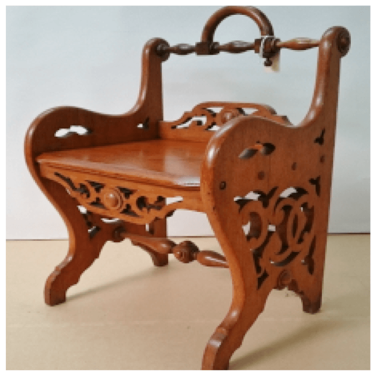 A small wooden stool with a handle sits on a table