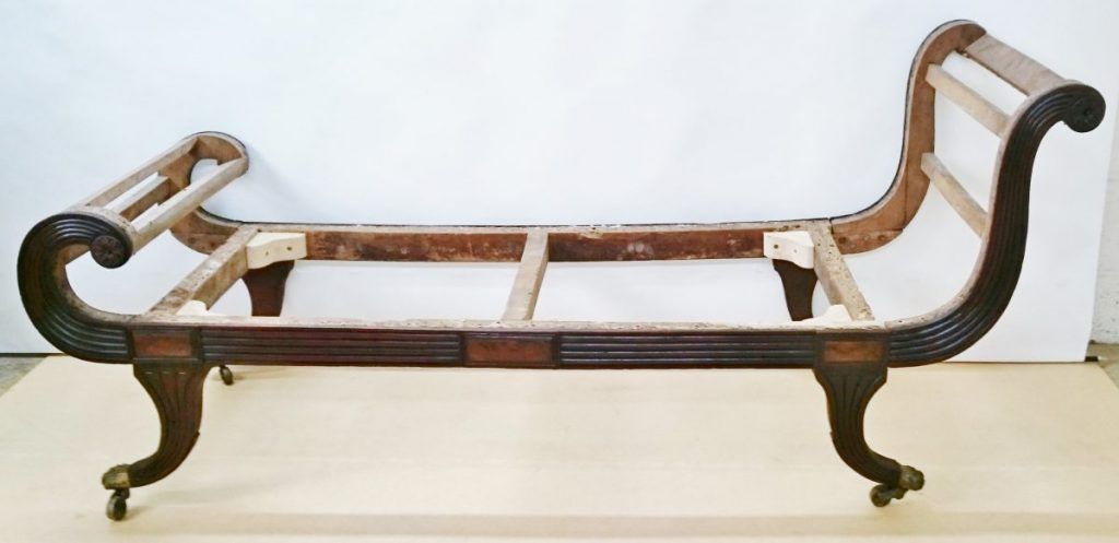 A wooden bench that looks like a sleigh is sitting on a table