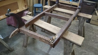 A wooden ladder is sitting on top of a wooden trestle in a workshop.
