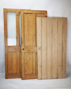 Three wooden doors are sitting next to each other on a white surface.