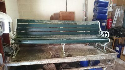 A green bench is sitting on top of a wooden table in a room.