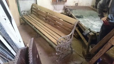 A wooden bench is sitting in a room next to a table.