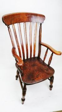 A wooden chair is sitting on a white surface.