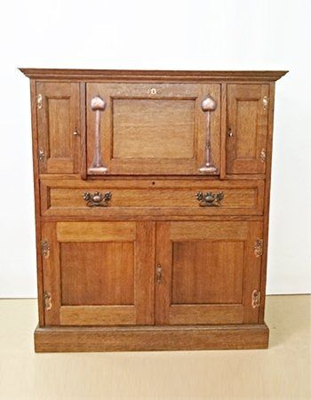 A wooden cabinet with drawers and doors is sitting on a wooden floor.