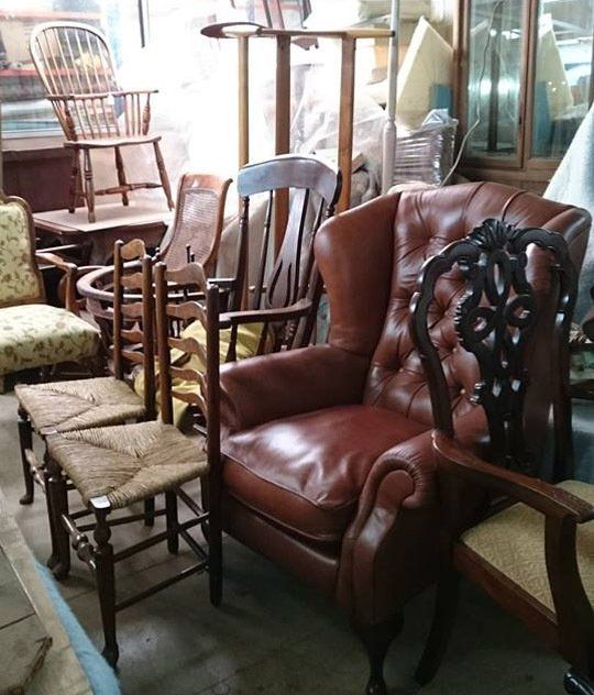 A room full of chairs including a brown leather chair