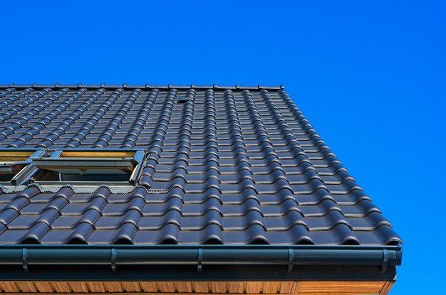 The roof of a house with a blue sky in the background.