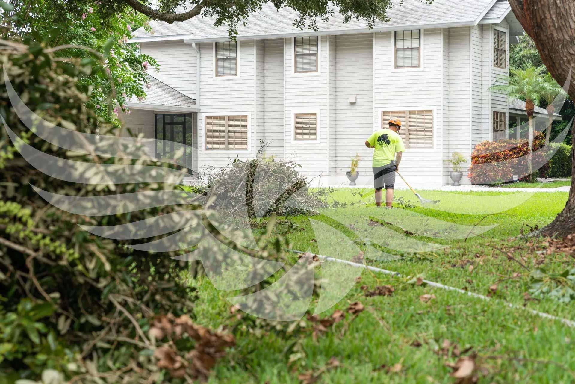 A man is mowing the lawn in front of a house.