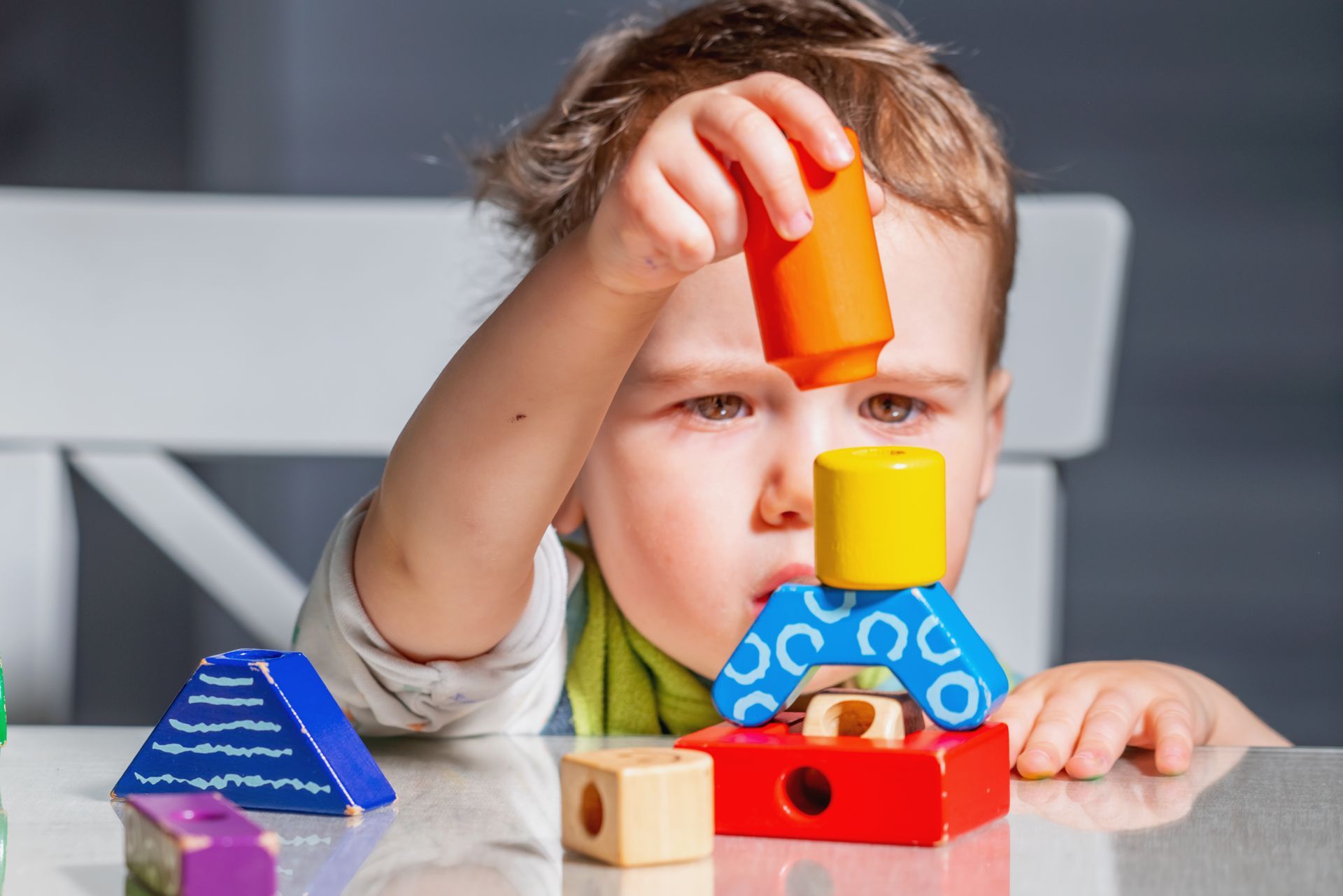 Toddler stacking colorful blocks during hands-on STEAM play at Lobitos Family Daycare