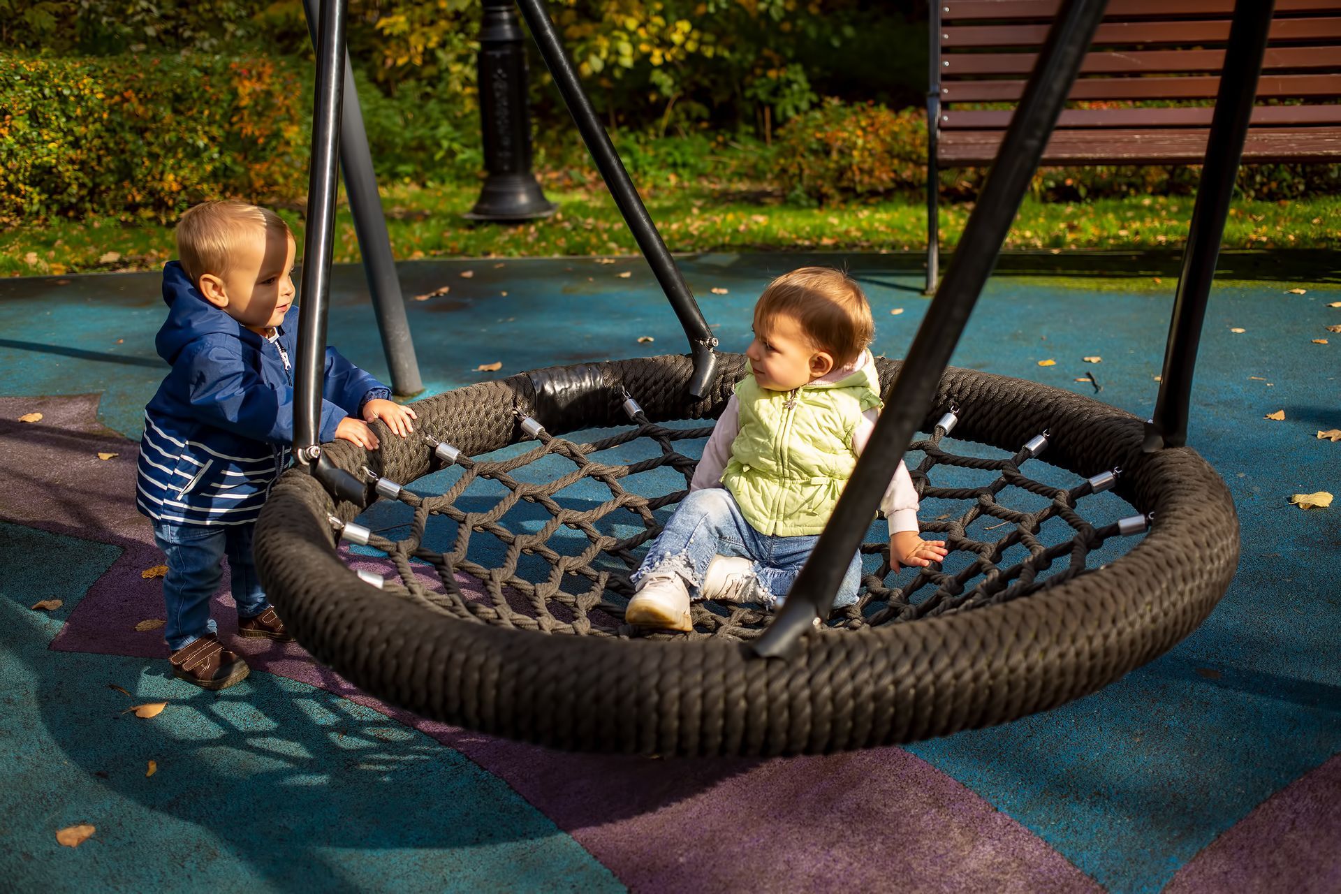 Children playing outside on a swing at a park