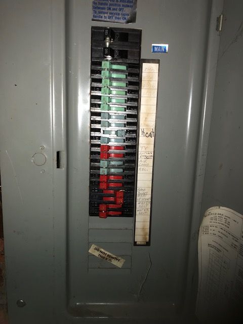 A close up of a fuse box with a receipt in front of it
