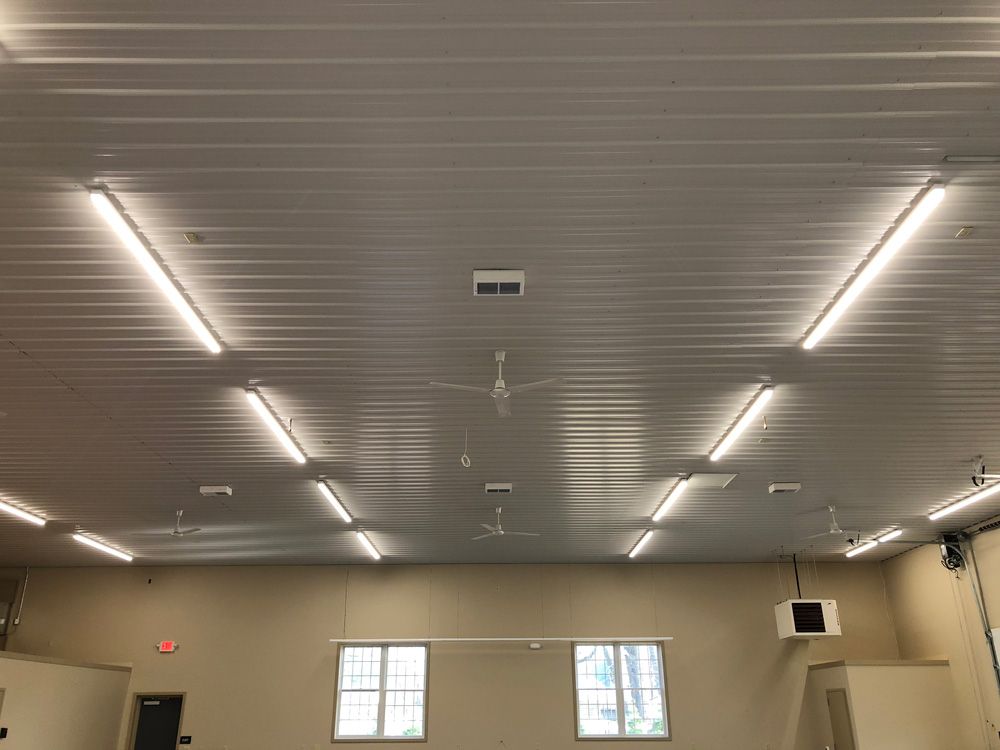A large room with a ceiling fan and lots of lights.