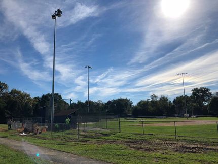 A baseball field with the sun shining through the clouds